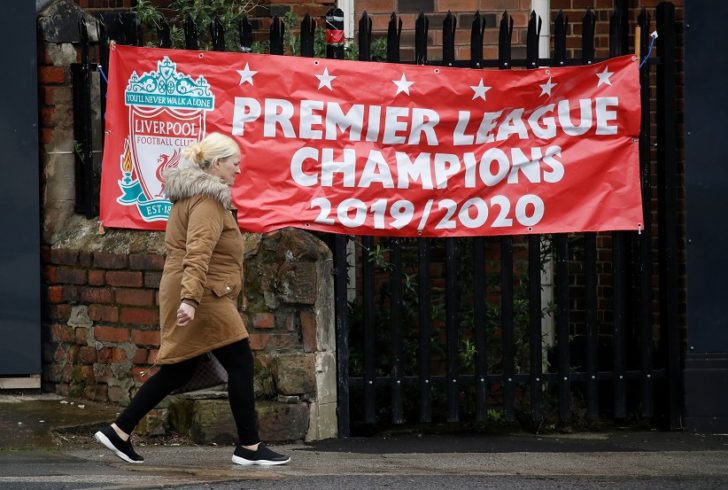 A woman walks past a banner stating