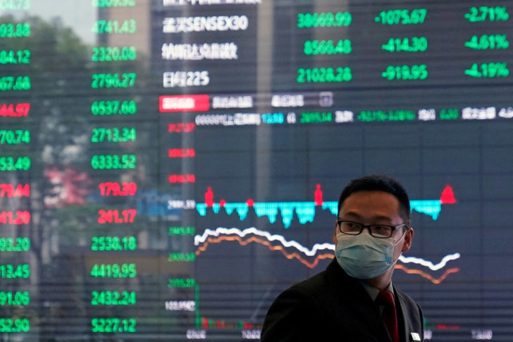 FILE PHOTO: A man wearing a protective mask is seen inside the Shanghai Stock Exchange building, as the country is hit by a new coronavirus outbreak, at the Pudong financial district in Shanghai
