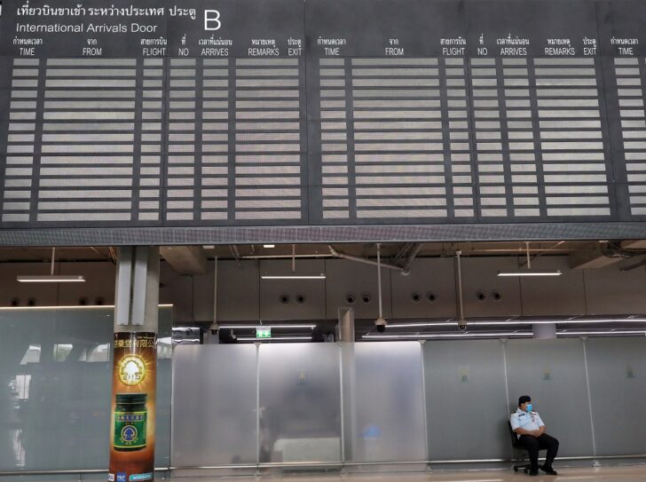 Man sits under the arrivals flight information board at Suvarnabhumi Airport in Bangkok 10 สายการบินบินเข้าไทย