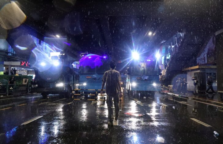 A man walks in the middle of the road during anti-government protests, in Bangkok