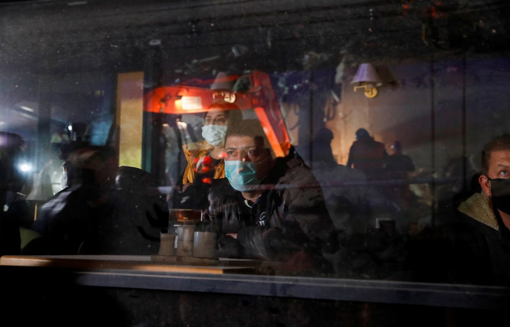 ชายคนหนึ่งนั่งมองปฏิบัติการค้นหาผู้รอดชีวิตจากหน้าต่างคาเฟ่ REUTERS/Murad Sezer TPX IMAGES OF THE DAY