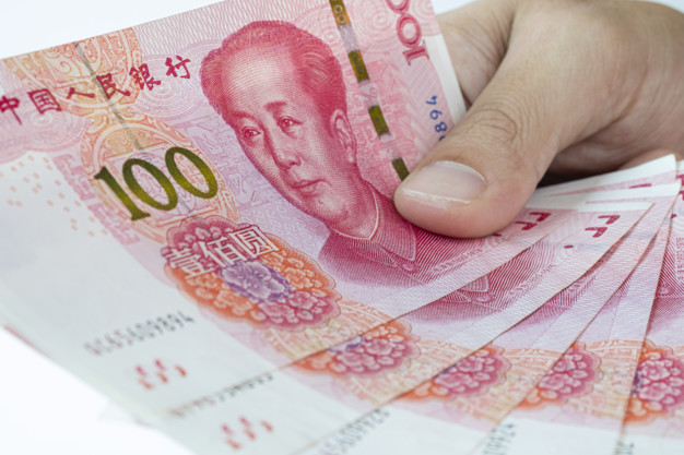 Hand holding China Yuan banknote on white background. Yuan bankn