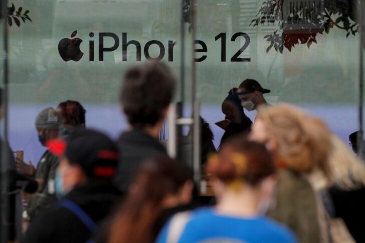 Customers wait in line outside an Apple Store to pick up Apple's new 5G iPhone 12 in Brooklyn, New York