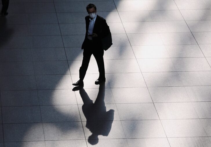 A man wearing a protective face mask walks inside a building at a business district, amid the coronavirus disease (COVID-19) outbreak, in Tokyo