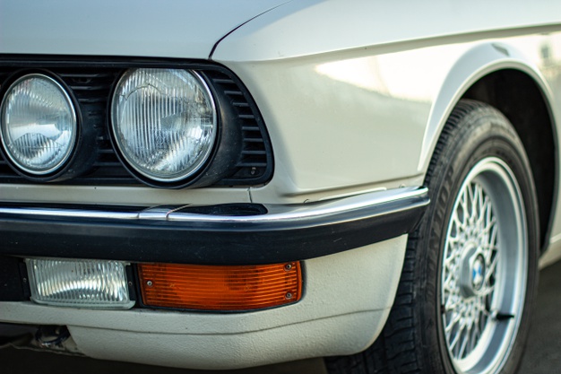 closeup-shot-round-headlights-white-vintage-classic-car_181624-21161