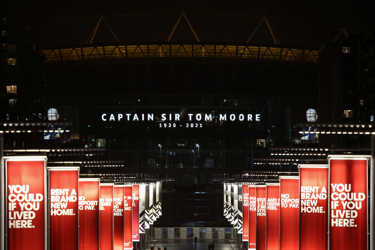 สนามกีฬาเวมบลีย์ (Wembley Stadium) เป็นสนามฟุตบอลที่ใหญ่ที่สุดในอังกฤษ  ขึ้นป้ายแสดงความอาลัย "CAPTAIN SIR TOM MOOR" ด้วย