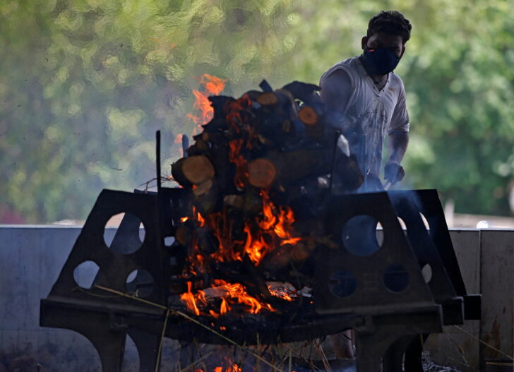 A man cremates his relative Hatayben Bharwad, who died from the coronavirus disease (COVID-19), at a crematorium in Ahmedabad