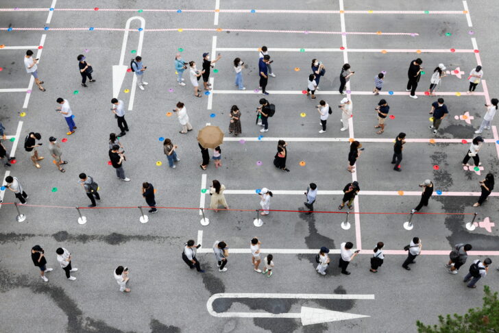 People wait in line for a coronavirus disease (COVID-19) test at a testing site which is temporarily set up at a public health center in Seoul