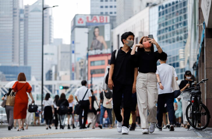 People walk by the south exit of Shinjuku station during the state of emergency in Tokyo