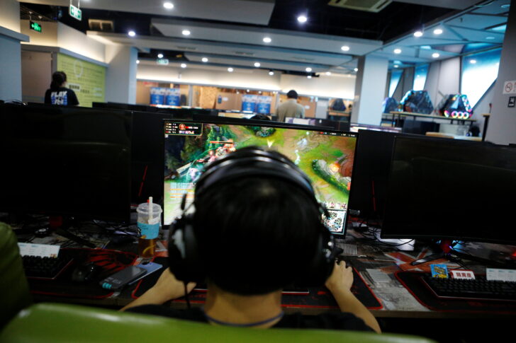 Man plays online game on a computer at an internet cafe in Beijing