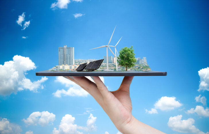 Ecological system solar energy in the city on the hand holding the tablet