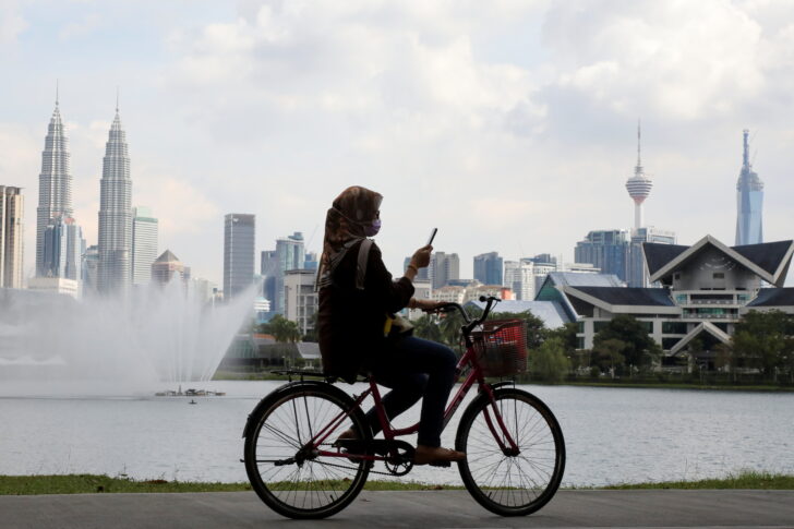A woman rides a bicycle at a park, amid the coronavirus disease (COVID-19) pandemic, in Kuala Lumpur