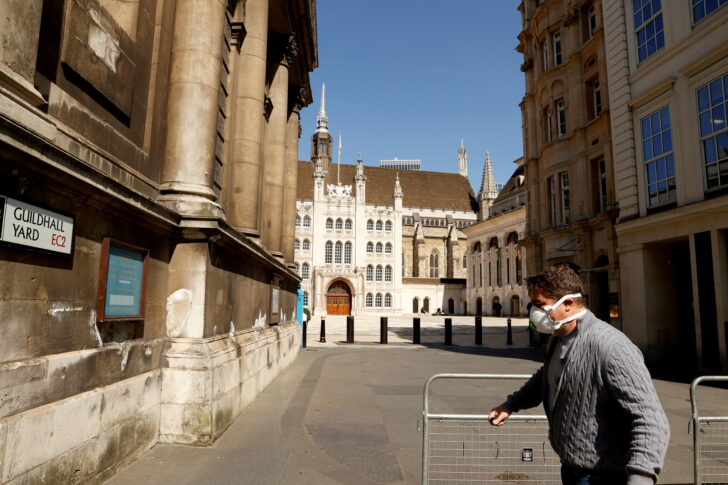 FILE PHOTO: A man wearing a protective mask outside Guildhall in the city of London as the spread of the coronavirus disease (COVID-19) continues,