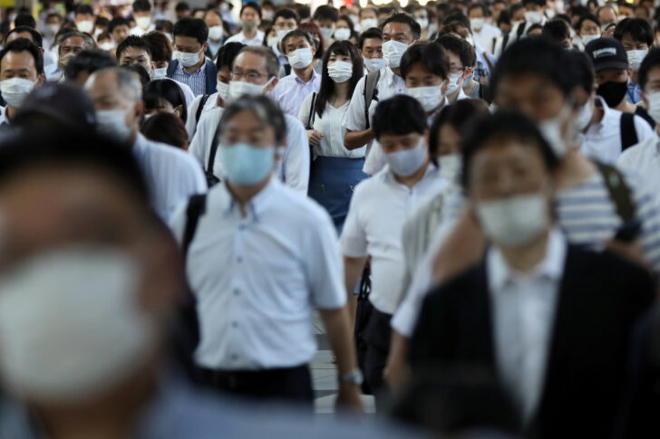 Commuters wearing face masks arrive at Shinagawa Station