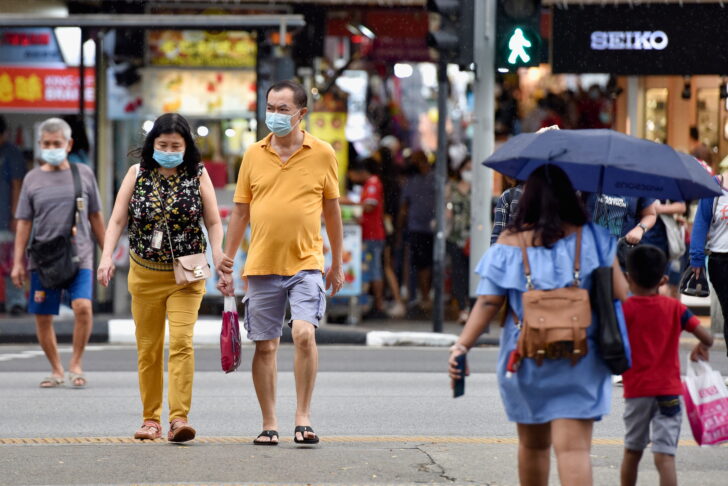 People cross a road in Singapore