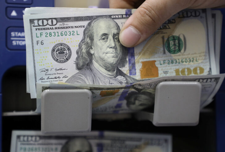 A man counts U.S. dollar banknotes at a currency exchange shop in Beirut US dollar