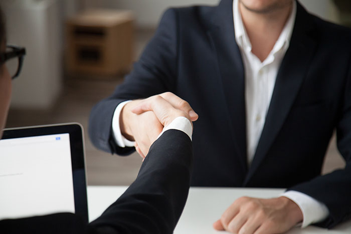 CEO shaking hand of male job applicant