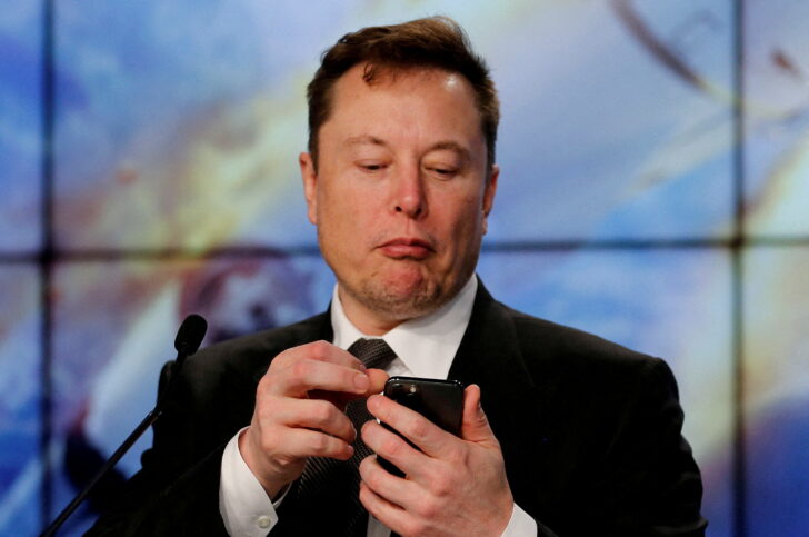 FILE PHOTO: Elon Musk looks at his mobile phone during a post-launch news conference to discuss the SpaceX Crew Dragon astronaut capsule in-flight abort test at the Kennedy Space Center Elon Musk