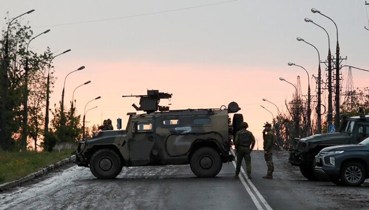 Service members of pro-Russian troops stand guard in Mariupol