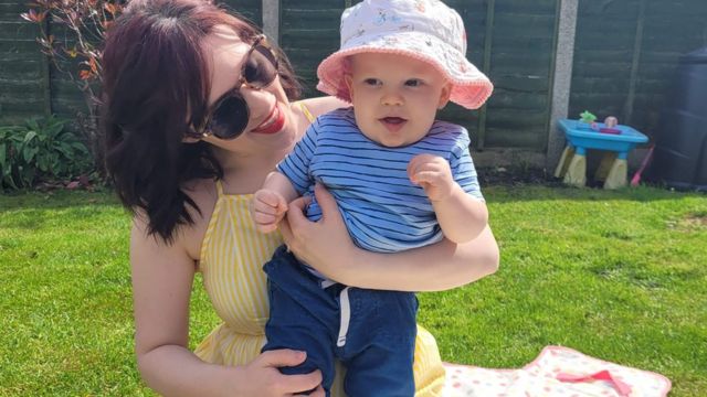 Rosie Forshaw, from Money Saving Rosie, sitting on a blanket with her one-year-old son