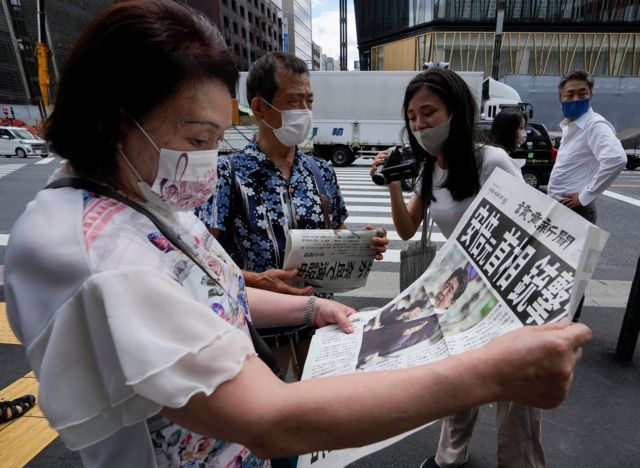 A woman reads a newspaper reporting former Japanese Prime Minister Shinzo Abe shot, in central Tokyo, Japan, 08 July 2022.