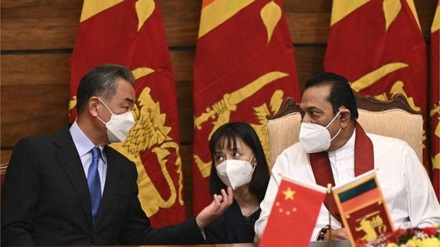 Chinese Foreign Minister Wang Yi (L) speaks with Sri Lanka's Prime Minister Malinda Rajapakse during an official meeting in Colombo on January 9, 2022.