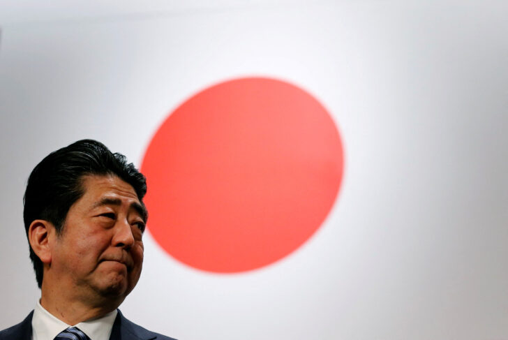 FILE PHOTO: Japan's Prime Minister Abe stands in front of Japan's national flag after his ruling LDP annual party convention in Tokyo ชินโส อาเบะ อดีตนายกรัฐมนตรีญี่ปุ่น รวมเรื่องควรรู้ ชีวิต-เส้นทางการเมือง