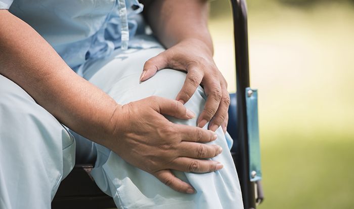Elderly woman sitting on wheelchairs with knee pain