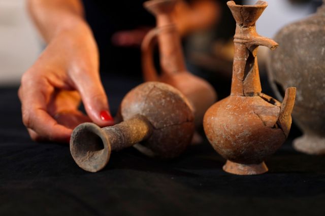 Archaeological evidence for the use of opium which resembled the shape of a poppy pod from 3,400 years ago is displayed by an amployee at the Israeli Antiquities Authority (IAA) in their laboratories in Jerusalem, 20 September 2022.