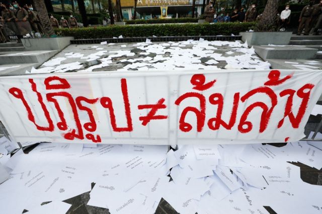 ป้ายข้อความของผู้ชุมนุม ที่รวมตัวหน้าศาลรัฐธรรมนูญ เมื่อวันที่ 10 พ.ย. 2564 เพื่อฟังคำวินิจฉัยกรณีการชุมนุม 10 ส.ค. 2563 ถูกร้องว่าเข้าข่ายการใช้สิทธิเสรีภาพเพื่อล้มล้างการปกครองระบอบประชาธิปไตยอันมีพระมหากษัตริย์ทรงเป็นประมุข