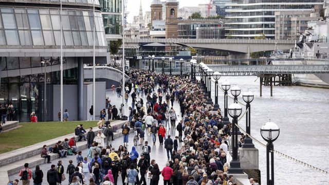 People queue on The Queen"s Walk along the River Thames as they wait to pay their respects to Queen Elizabeth II