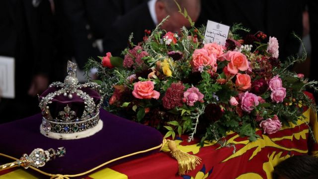 A handwritten card on top of the Queen's coffin reads: "In loving and devoted memory. Charles R".