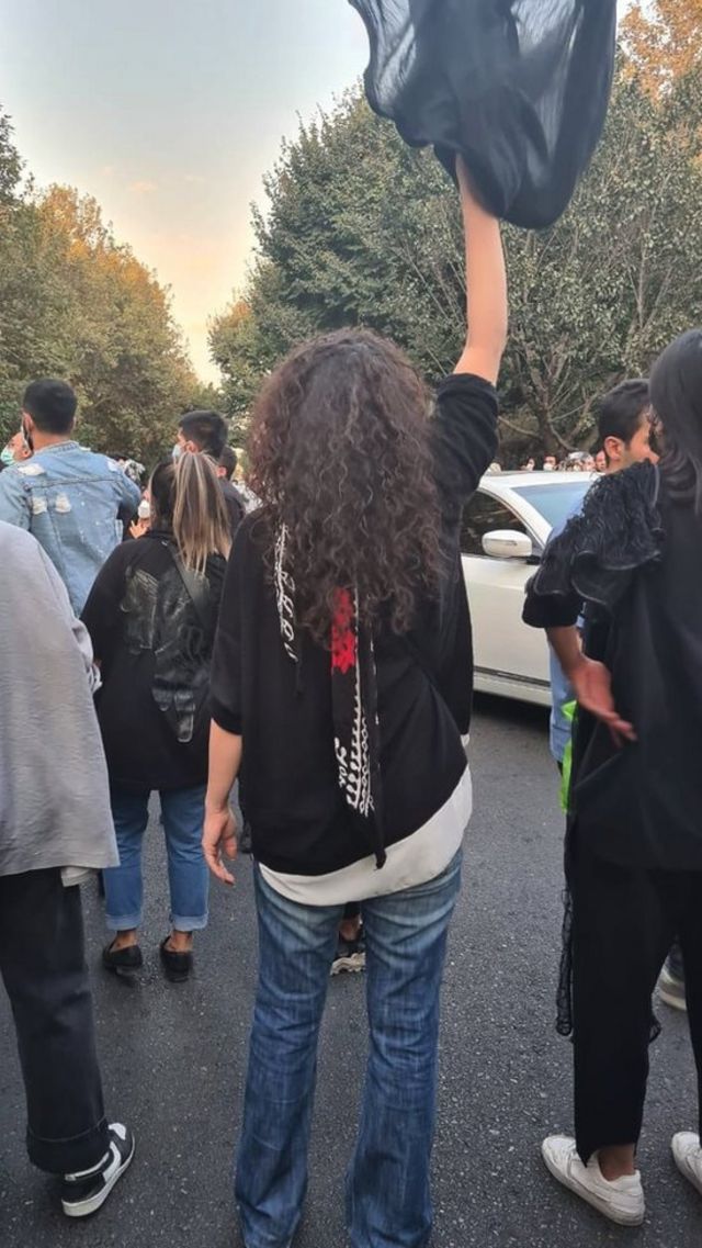 Woman holding hijab above her head