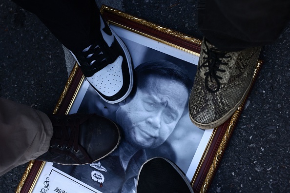 ผู้ประท้วงวางเท้าบนกรอบรูปนายกรัฐมนตรี ประยุทธ์ จันทร์โอชา ระหว่างการประท้วงเรียกร้องให้ถอดถอนที่อนุสาวรีย์ประชาธิปไตยในกรุงเทพฯ เมื่อวันที่ 23 สิงหาคม พ.ศ. 2565