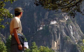 ชาวภูฏานยืนอยู่ด้านหน้า Taktsang Monastery หรือวัดถ้ำเสือ ในประเทศภูฏาน