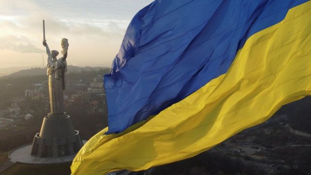 Ukraine's biggest national flag on the country's highest flagpole and the giant Motherland monument are seen at a compound of the World War II museum in Kyiv, Ukraine