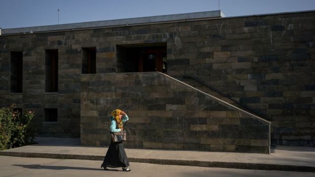 A female student walks past a campus entrance at Kabul University