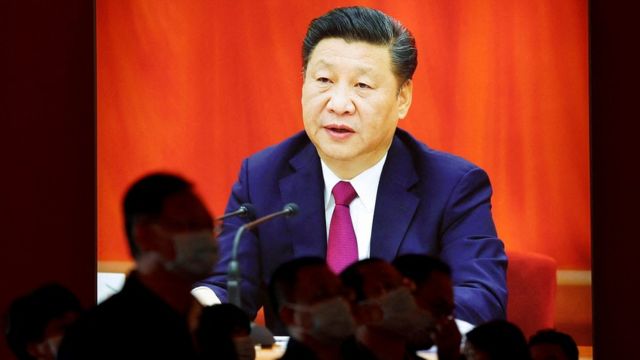 Visitors stand in front of an image of Chinese President Xi Jinping