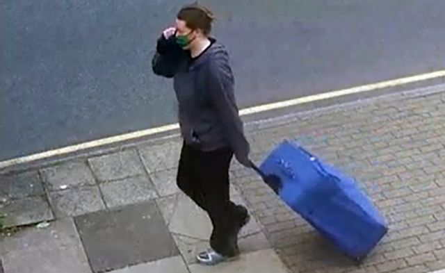 Jemma Mitchell pulling a blue suitcase through the streets of London