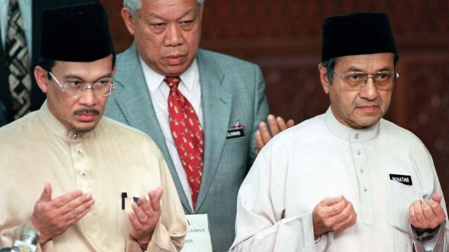 Malaysian Prime Minister Mahathir Mohamed (R) and Deputy Prime Minister and Finance Minister Anwar Ibrahim offer prayers at the Malaysian 1998 Budget report