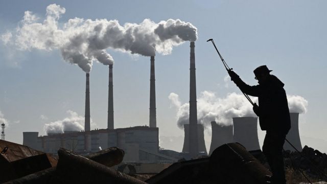 A worker uses a torch to cut steel pipes near the coal-powered Datang International Zhangjiakou Power Station at Zhangjiakou China.