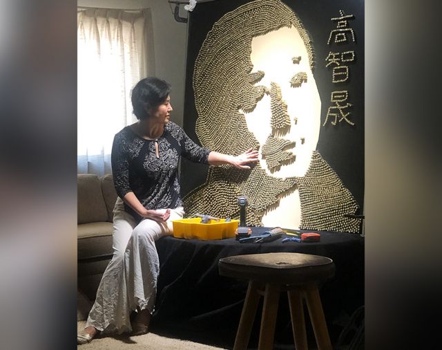 Geng He with a picture of her husband made of empty bullet shells
