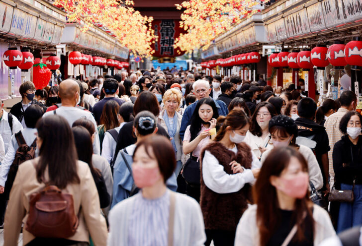 Visitors including from abroad stroll at Nakamise street leading to Senso-ji temple at Asakusa district in Tokyo