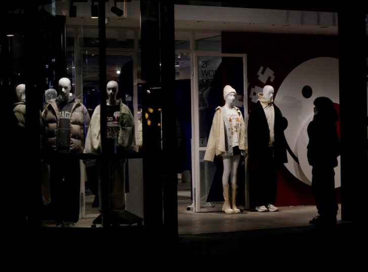 A man stands in front of a show window at a shopping district in Tokyo เงินเฟ้อ คนไม่มีกำลังซื้อ