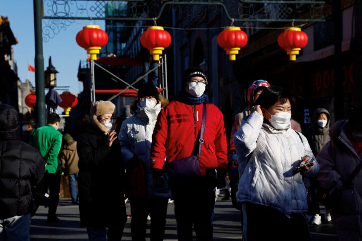 People walk past Qianmen street decorated with lanterns ahead of the Chinese Lunar New Year, in Beijing เศรษฐกิจจีน