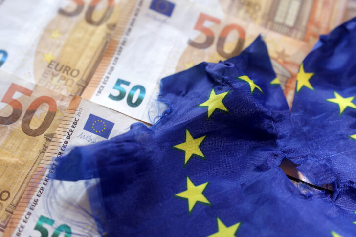 FILE PHOTO: Illustration shows Euro banknotes and torn EU flag เศรษฐกิจยูโรโซน