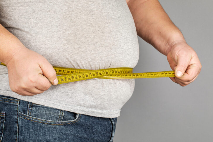 A,Man,Measures,His,Fat,Belly,With,A,Measuring,Tape.