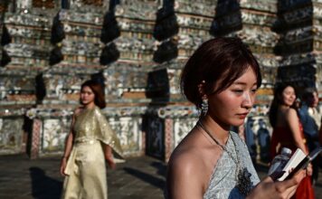 นักท่องเที่ยวแต่งชุดไทย ถ่ายภาพคู่กับพระปรางค์วัดอรุณฯ