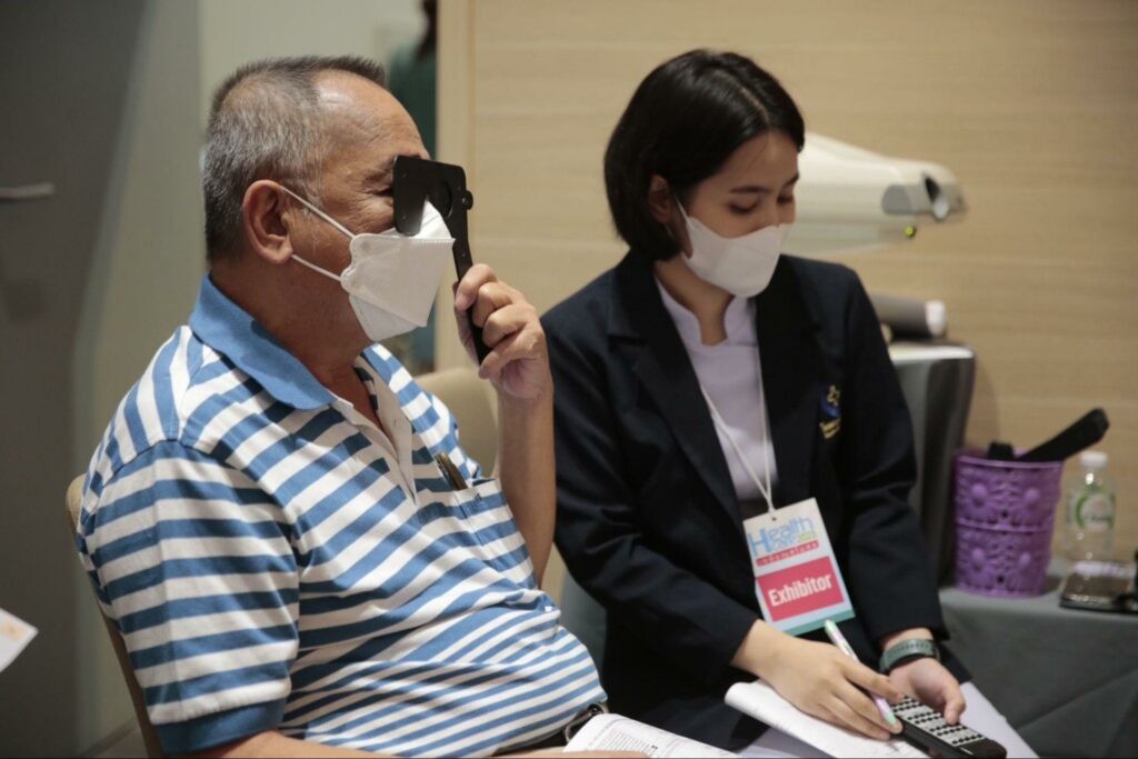 ชายสูงวัย รับการตรวจสายตา งาน Healthcare 2023