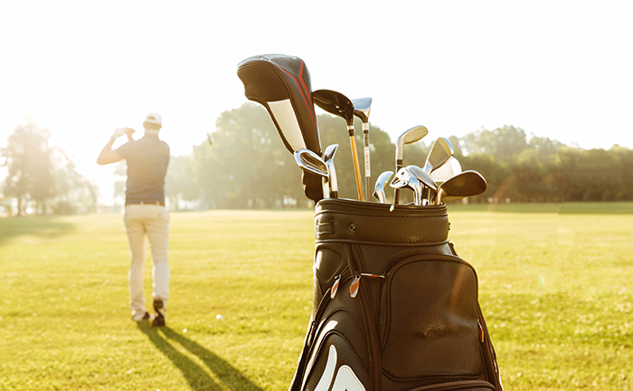 Back view of a male golfer swinging golf club